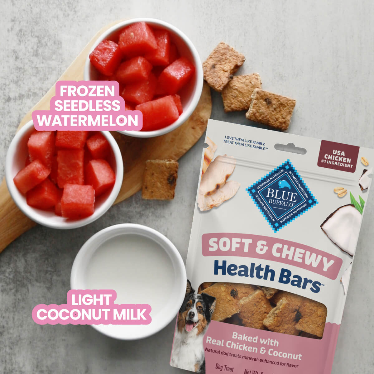 Blue Buffalo Soft & Chewy Health Bars dog treats next to a bowl of pink food topped with treat pieces.