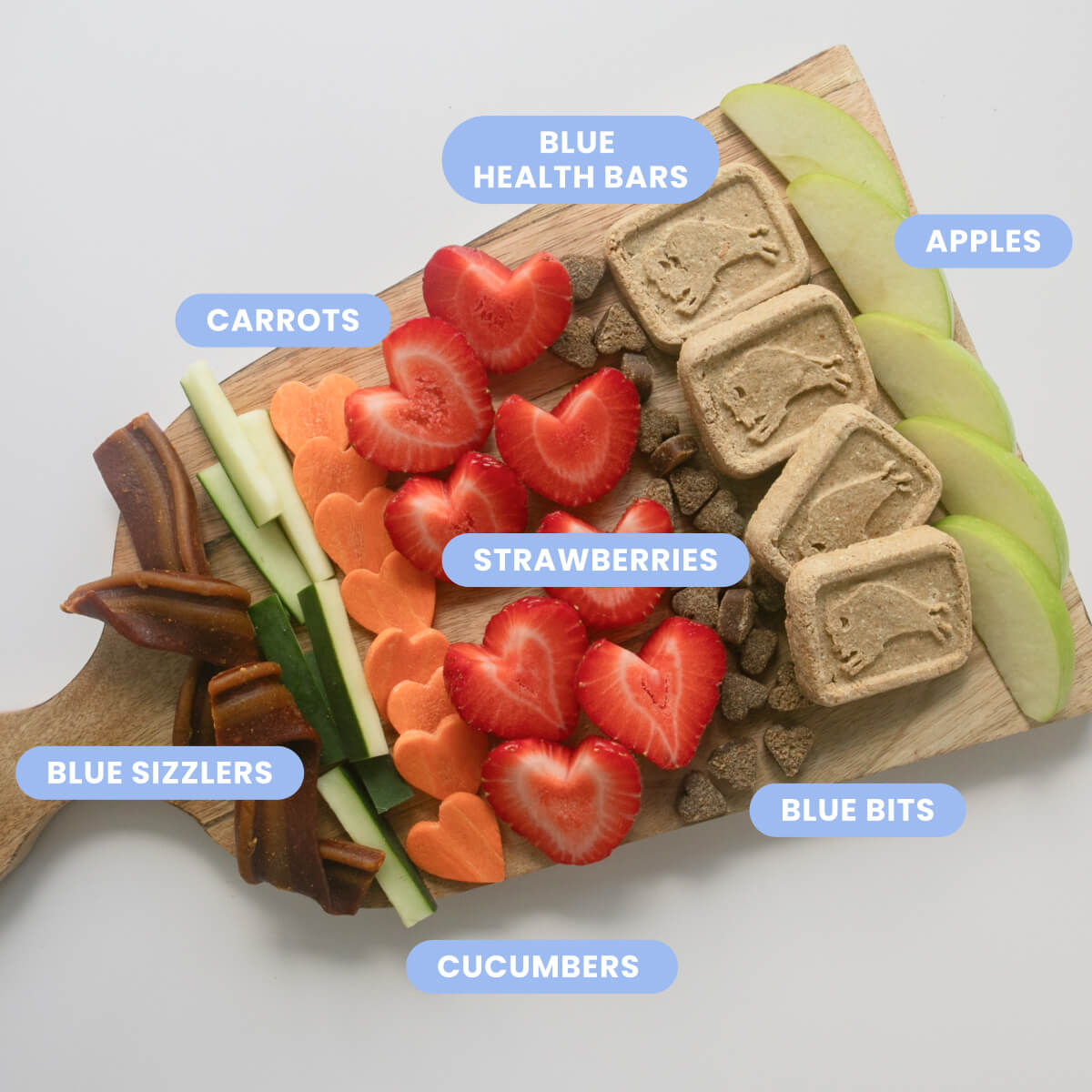 Dog treat platter: Blue Health Bars, Bits, Sizzlers, strawberries, apples, carrots, cucumbers