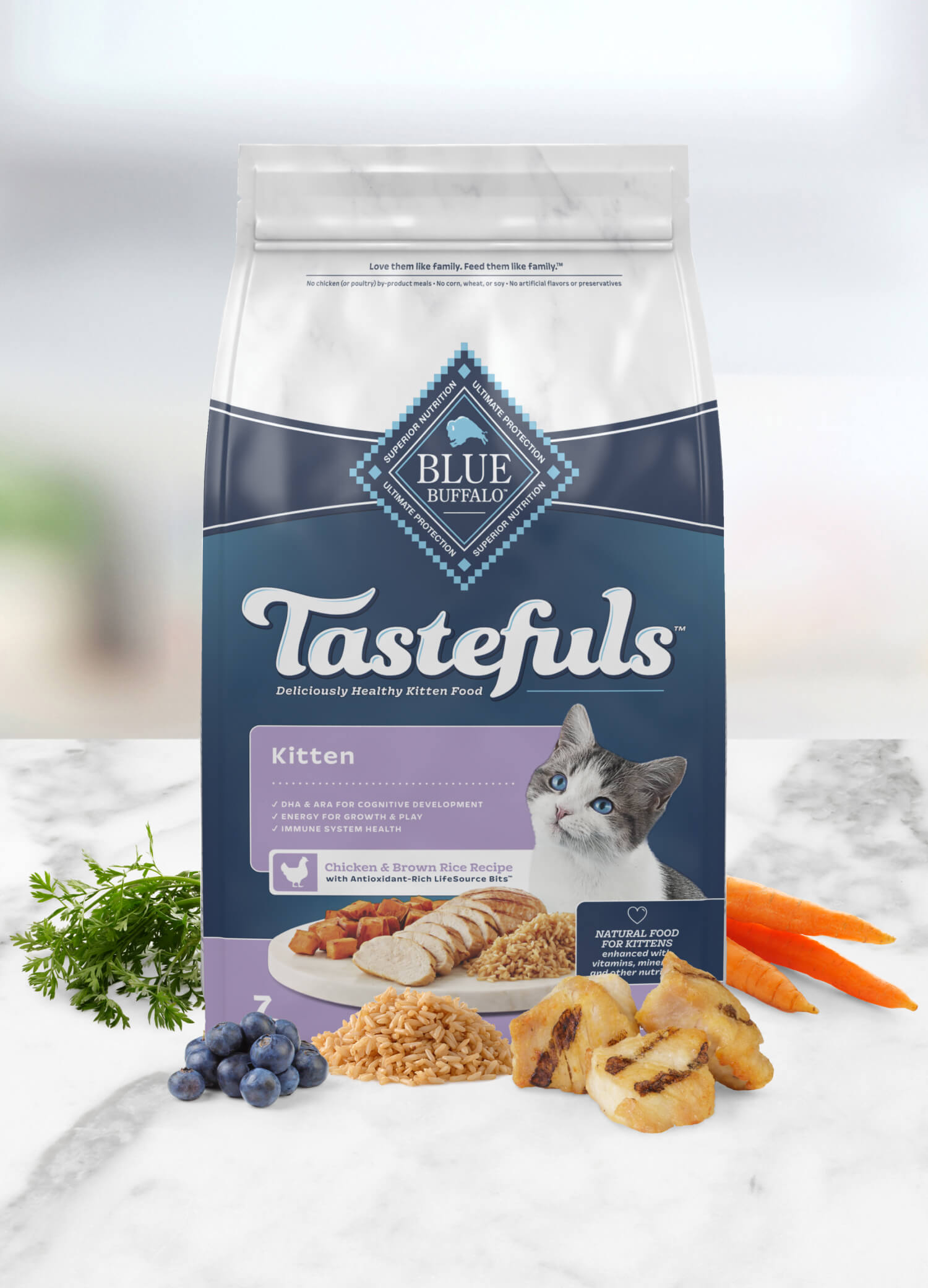 A bag of Blue Buffalo Tastefuls kitten food with chicken & brown rice, surrounded by ingredients like carrots and blueberries.