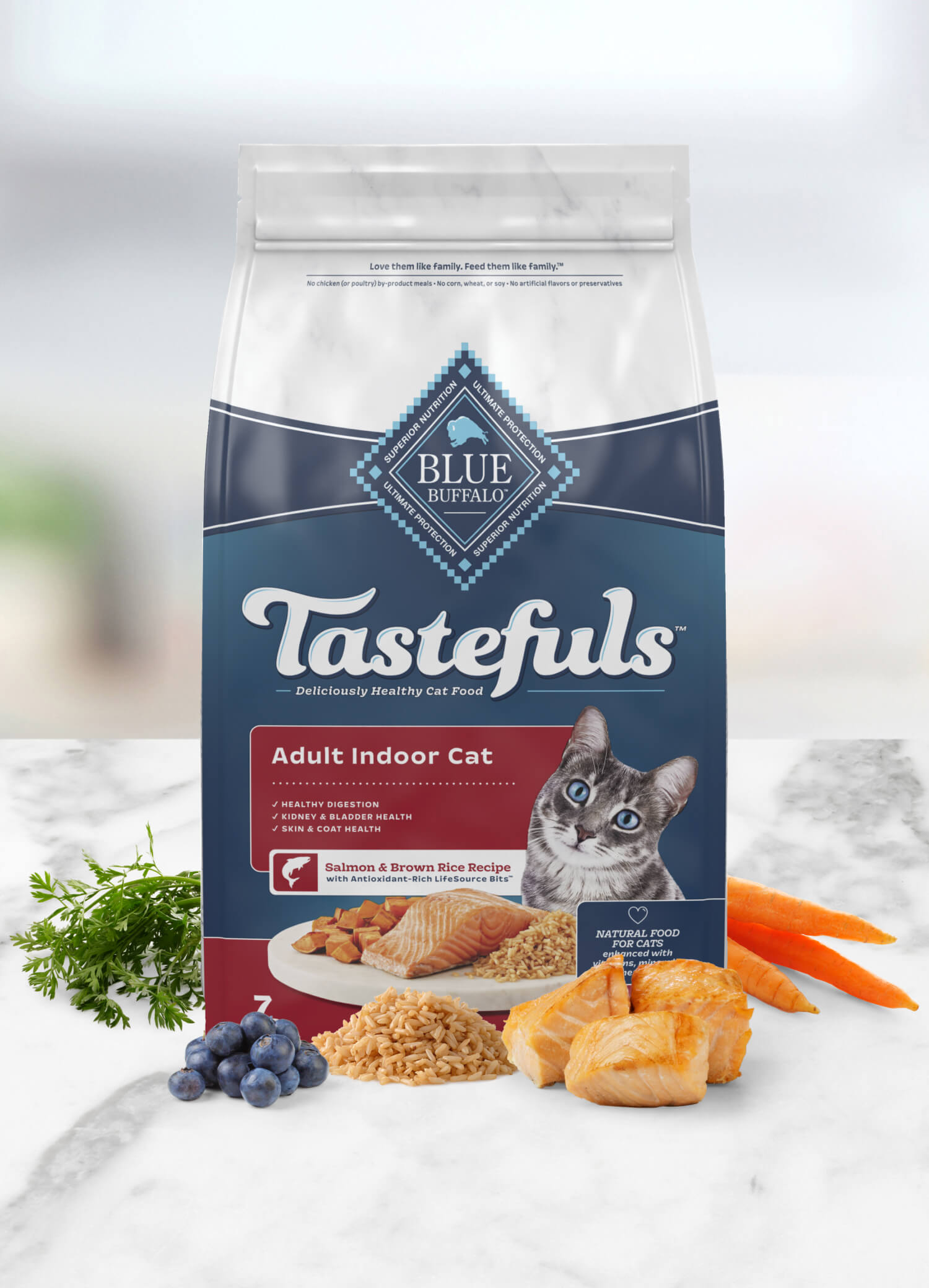 A bag of Blue Buffalo Tastefuls cat food for adult indoor cats, featuring salmon and brown rice recipe, shown with fresh ingredients like greens, carrots, and fish.