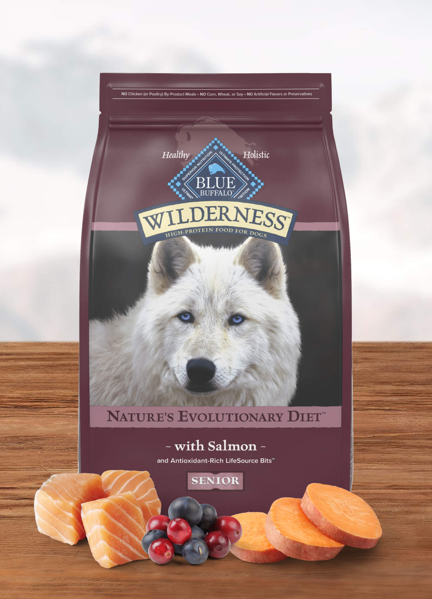 A bag of Wilderness salmon senior food is behind salmon filets, a mound of cranberries and blueberries, and slices of sweet potato.